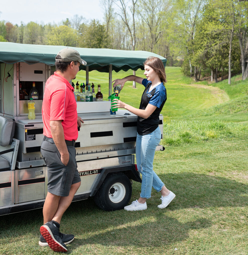 Bartender serving drinks at the cart on the golf green
