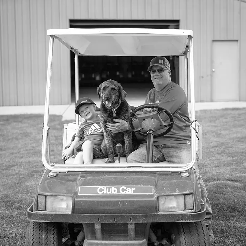 Man and Child with dog in a Golf Cart copy